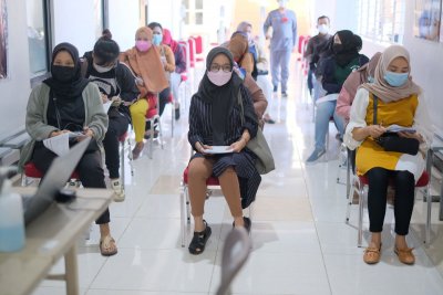 Peserta vaksinasi saat menunggu panggilan skrining oleh petugas dari IIK Bhakta