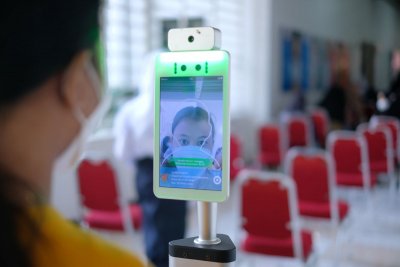 Salah satu peserta vaksinasi harus mengecek suhu sebelum memasuki Bhakta Hall.